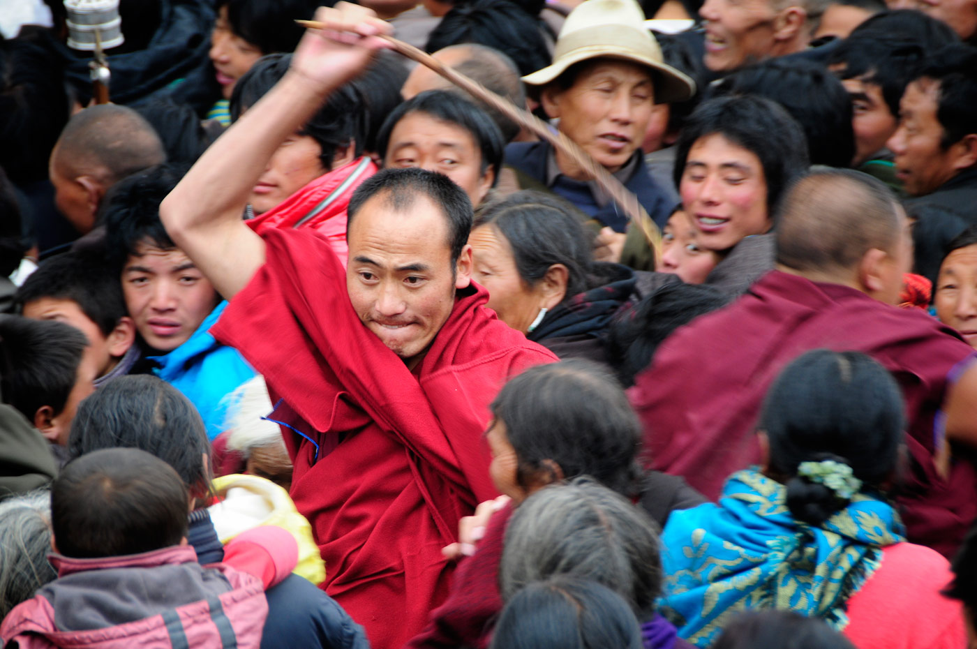 Chinese monch beating Tibetan Pilgrims, Langmusi, Tibetan China, 2010